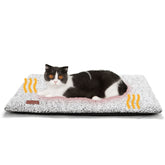 Cama auto-caliente Mora Pets para gato descansando en sofá, calor suave