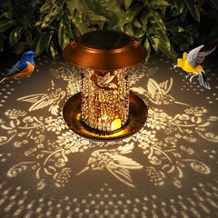 Lámpara solar de cobre retro Tepaken proyecta siluetas de colibrí en el suelo.