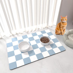 Alfombrilla BLESWIN para alimentación de mascotas con patrón cuadriculado azul y blanco, estética y funcionalidad.