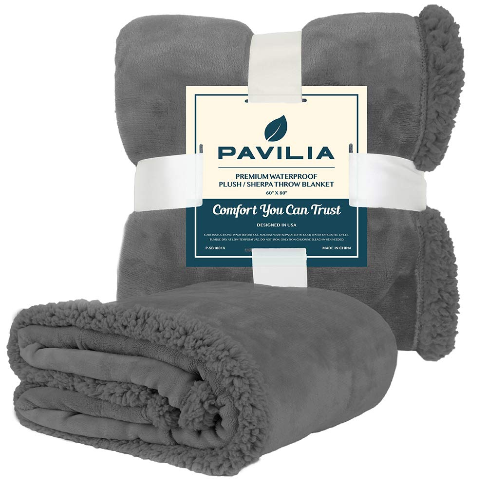 Manta Pavilia en gris oscuro que combina con la decoración.