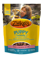 Premios de Zukes Puppy Naturals en mano para reforzar obediencia